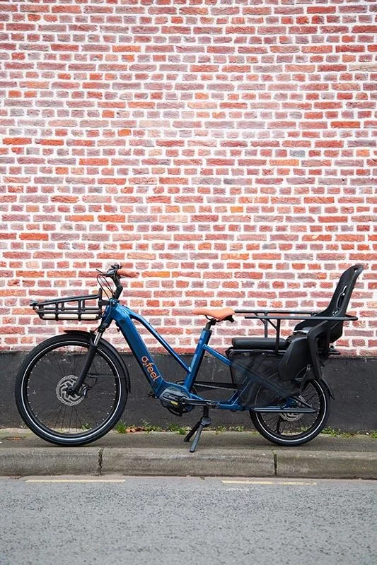O2feel Equo longtail met kinderzitje tegen een bakstenen muur